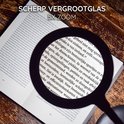 Une loupe noire avec un zoom 5x au-dessus d'une page de texte.