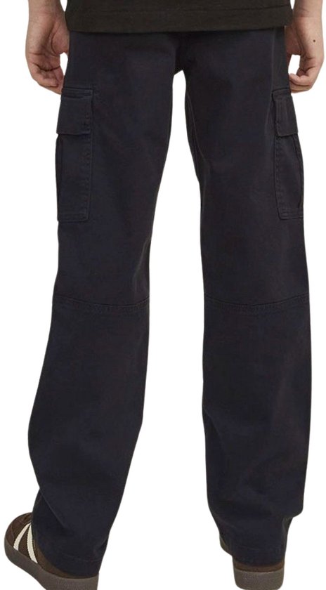 Achterzijaanzicht van een jongen in donkergrijze cargo broek en bruine sneakers.