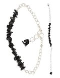 Zilverkleurig schakelarmbandje met ruwe zwarte steentjes, los op een witte achtergrond.