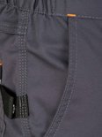 Détail du pantalon de travail gris foncé avec coutures orange et une boucle noire près de la poche.