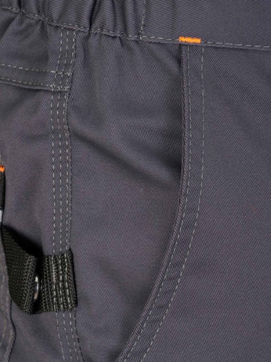 Détail du pantalon de travail gris foncé avec coutures orange et une boucle noire près de la poche.