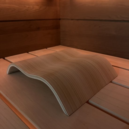 Houten saunahoofdsteun in golfvorm op een houten bank.