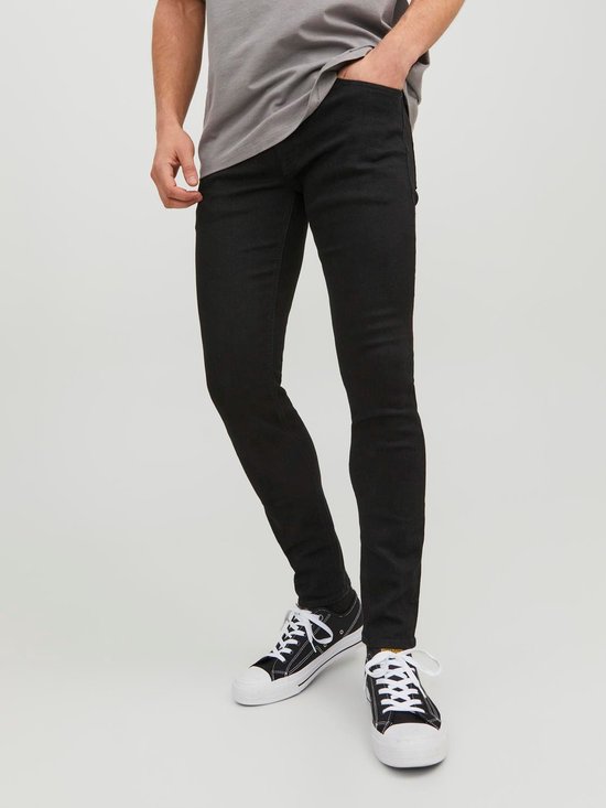Man met strakke zwarte jeans en grijze t-shirt