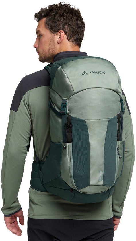Rugzak gedragen door een man, met de VAUDE-logo op de bovenkant. De rugzak is lichtgroen en donkergroen.