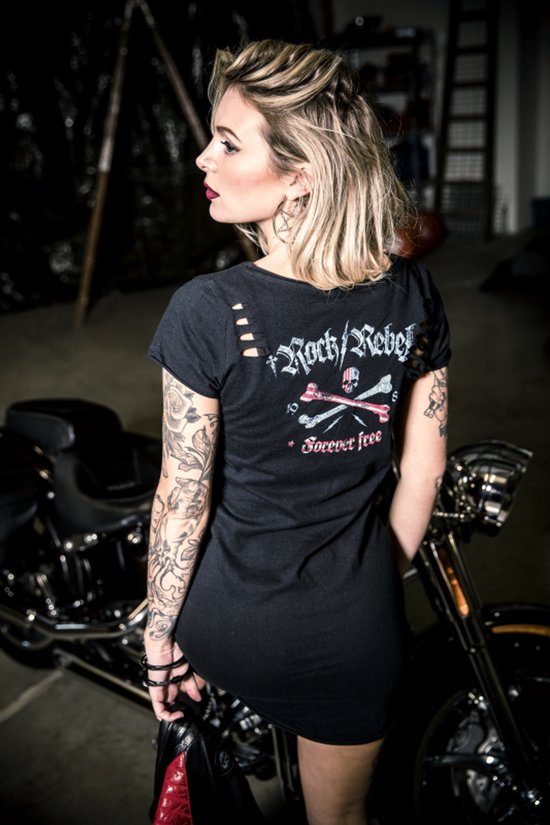 Vrouw met getatoeëerde armen in zwarte jurk met gescheurde schouders, 'Rock/Rebel' en doodshoofdprint.