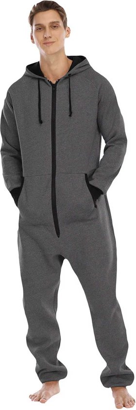 Man in een grijze onesie met capuchon en zwarte rits. Casual staand met handen in de zakken.