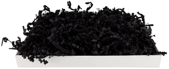 Bandes de papier noires et froissées remplies dans un bac blanc allongé, sur fond blanc.