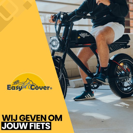 Man op zwarte fatbike met grote koplamp, rijdend op een parkeerplaats.