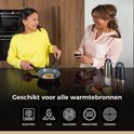 Twee vrouwen in een keuken, één bakt een ei, de ander drinkt wijn.