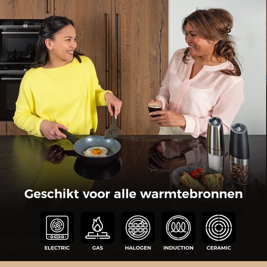 Twee vrouwen in een keuken, één bakt een ei, de ander drinkt wijn.