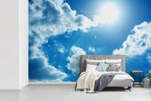 Behang - Fotobehang Zon tussen de wolken aan de hemel - Breedte 390 cm x hoogte 260 cm