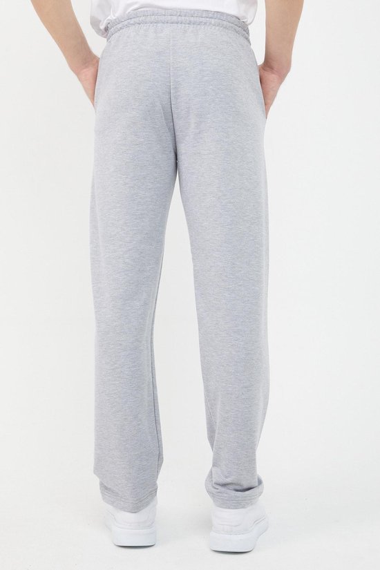 Achterkant van een lichtgrijze joggingbroek voor heren, met witte sneakers.