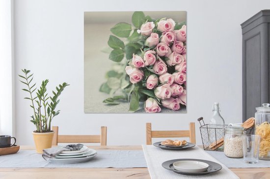 Un grand livre de roses roses repose sur une table Toile 90x90 cm - Tirage photo sur toile (Décoration murale salon / chambre) / Peintures Fleurs sur toile