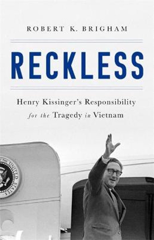 Boekcover van 'Reckless: Henry Kissinger's Responsibility for the Tragedy in Vietnam'. Een zwart-witfoto van Henry Kissinger met opgeheven hand.