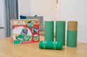 Opgerolde groene puzzelmat met clips, drie groene kartonnen kokers en de doos van Jumbo Puzzle & Roll.