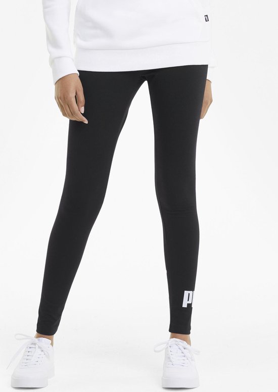 Model in zwarte PUMA legging met wit logo op de linker broekspijp en een witte PUMA hoodie.