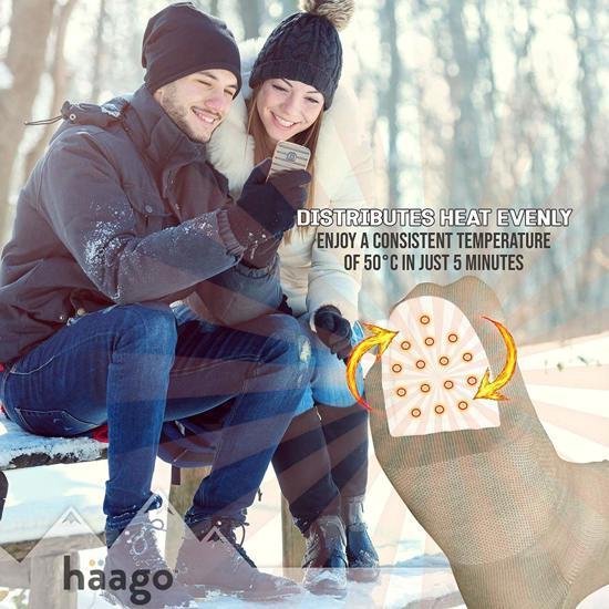Een koppel op een besneeuwde bank kijkt op een telefoon. Een close-up toont een teenthermowarmers met warmteverdeling.