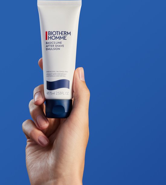 Hand die een witte tube Biotherm Homme Basics Line After Shave Emulsion vasthoudt.