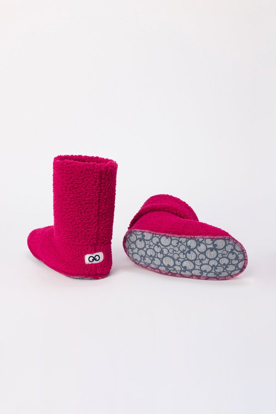 Roze fuzzy laarsjes, één met symbool, één met omgeslagen boord en grijze zolen.