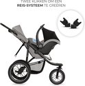 Grijze kinderwagen met zwarte reiswieg en adapters. Tekst: Twee klikken om een reis-systeem te creëren.