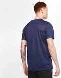 Man met rood haar draagt een donkerblauw Nike sportshirt, achterkant zichtbaar. Zwart afgezet.