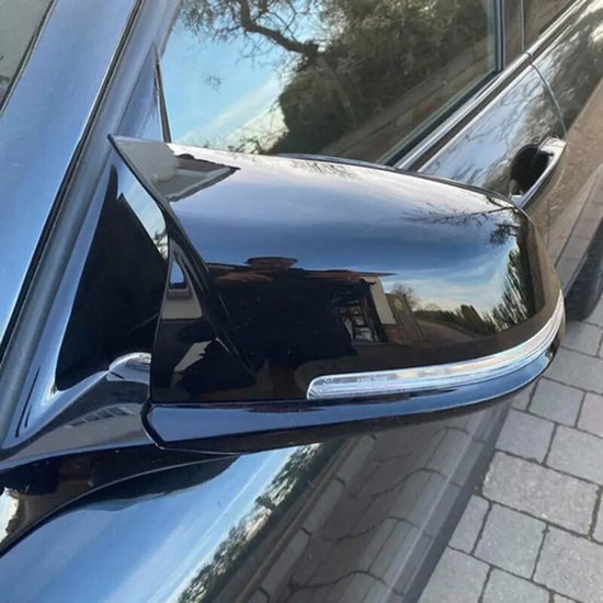 Zwarte glimmende buitenspiegel van een auto met een indicatorlampje.