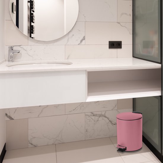 Poubelle rose avec pédale dans une salle de bain moderne