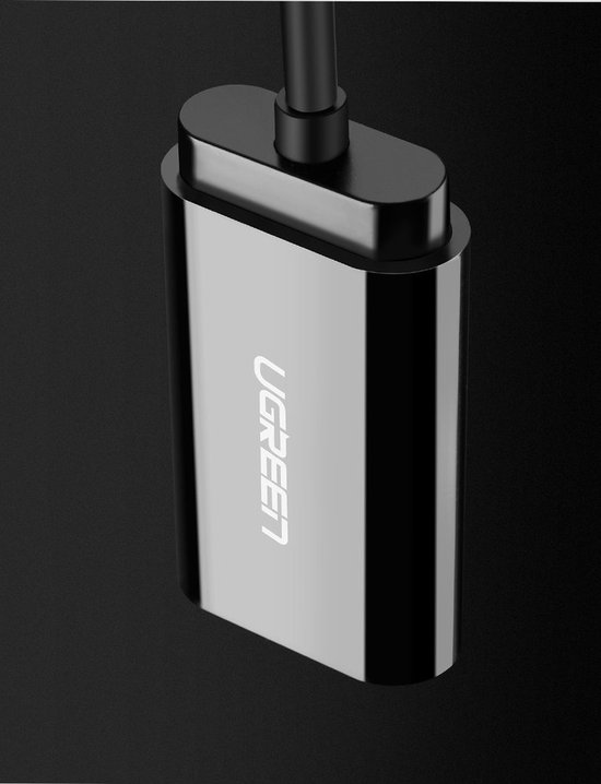 Zilverkleurige Ugreen adapter in close-up, op een donkere achtergrond.