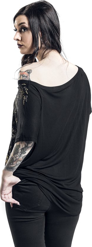 Model van achterkant gezien, draagt een zwart T-shirt met off-shoulder hals en zichtbare tatoeages op haar arm.