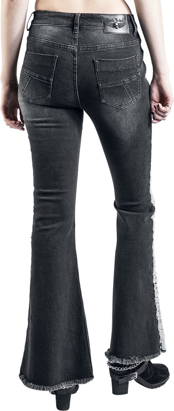 Achterkant van een model in donkergrijze bootcut jeans met ripped details, witte franjes en sterknopen aan de zijkant.