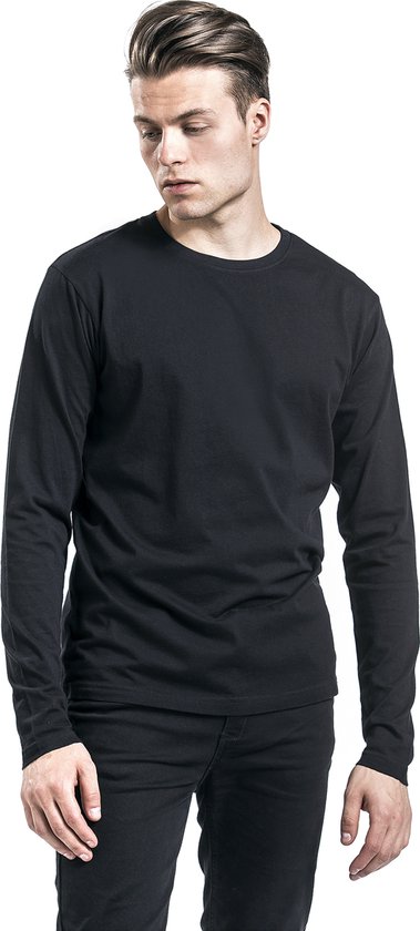 Man met blond haar in zwart longsleeve shirt, zwarte jeans.