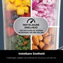 Close-up van een Ninja blenderkan met daarin vier compartimenten: aardbeien, blauwe bessen, mango, ui, amandelen en boerenkool.