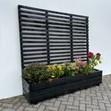 Zwarte plantenbak met klimrek, gevuld met gele en rode bloemen.
