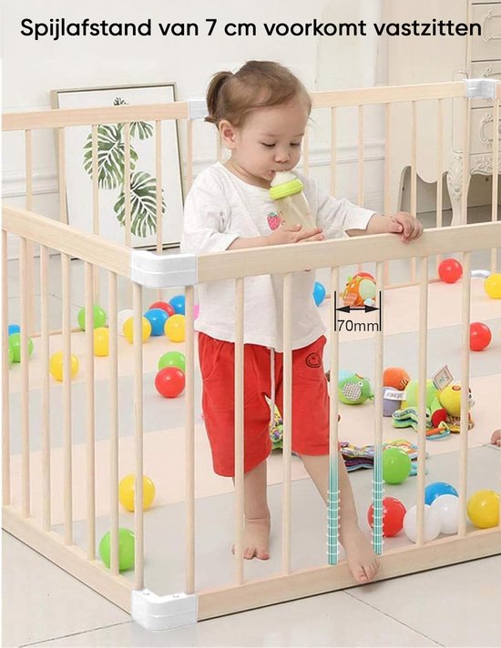 Houten babybox met een kind dat een fles drinkt, met een meting van de spijlafstand.