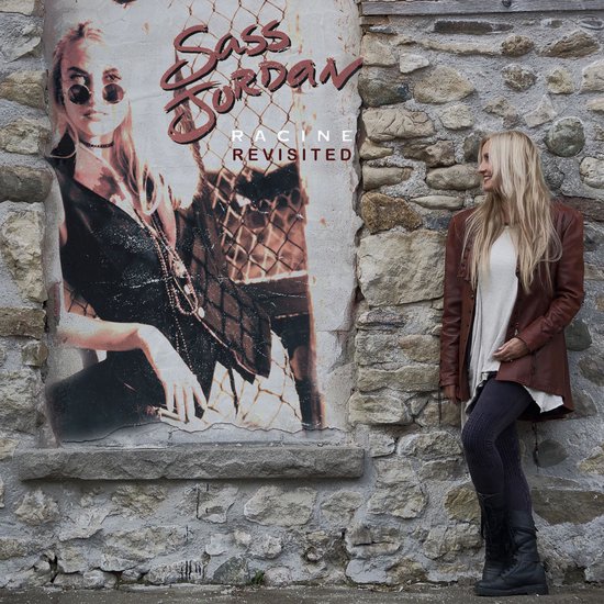 Een vrouw met lang blond haar en een bruine leren jas staat naast een poster van Sass Jordan.