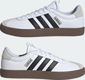 Twee witte adidas sneakers met bruine zool en zwarte strepen.