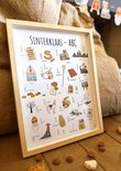 Gekaderde Sinterklaas ABC poster op houten vloer met bruine zakken en koekjes op de voorgrond.