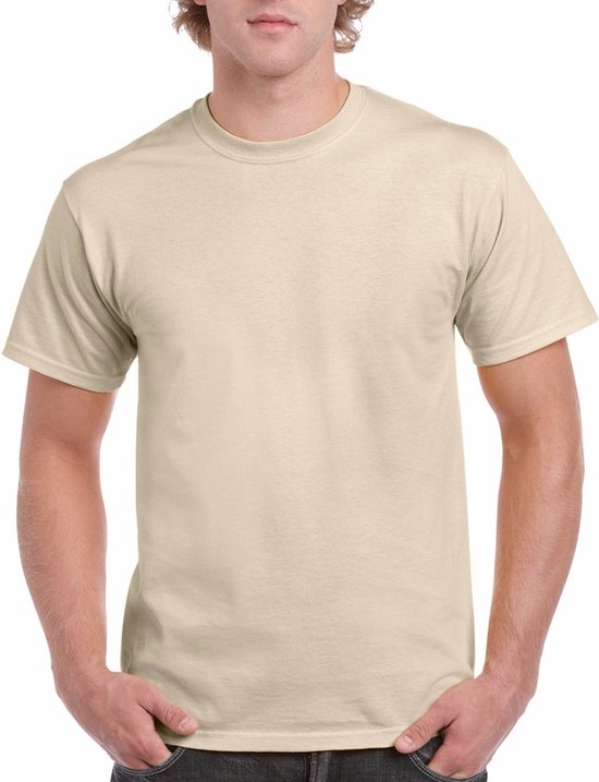 Homme, mains dans les poches, portant un t-shirt de couleur crème avec col rond et manches courtes.