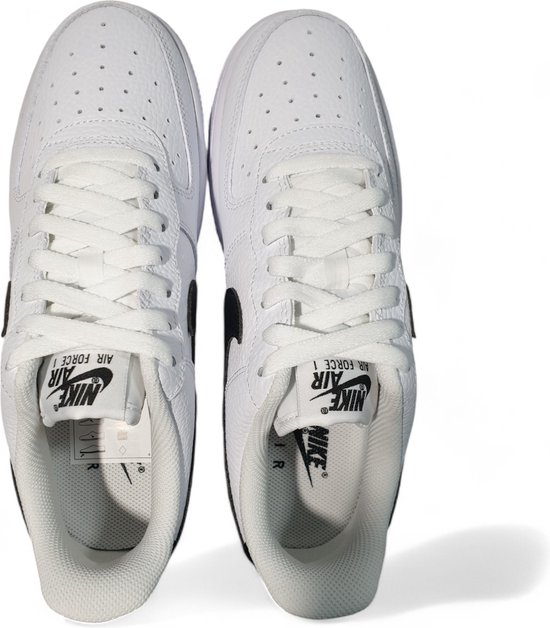 Bovenkant van witte Nike Air Force 1 sneakers met witte veters en zwarte Nike Air logo's op de tong.