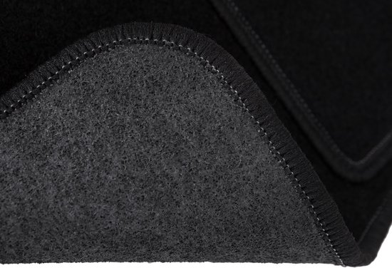 Détail du revers d'un tapis de voiture en velours noir avec surpiqûres grises.
