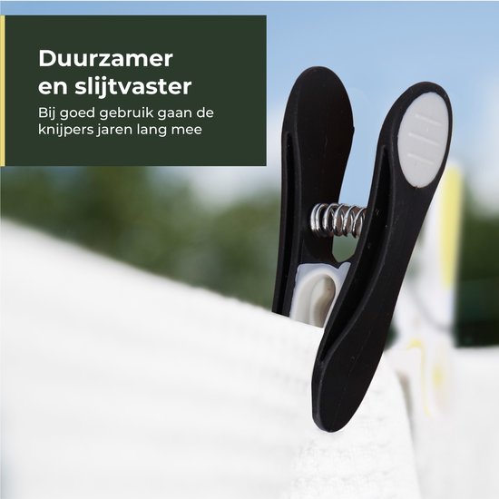 Een zwarte knijper met metalen veer klemt witte stof.