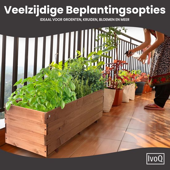 Houten plantenbak met verse kruiden op een balkon, water gegeven door een vrouw.
