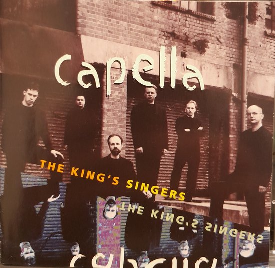 Zes mannen in donkere kleding staan voor een bakstenen muur, de groepsnaam 'Capella' en 'The King's Singers' staan boven hen.