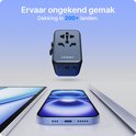 Voomy reisstekker in het midden, met een smartphone, tablet en laptop op de voorgrond. Dekking in 200+ landen.