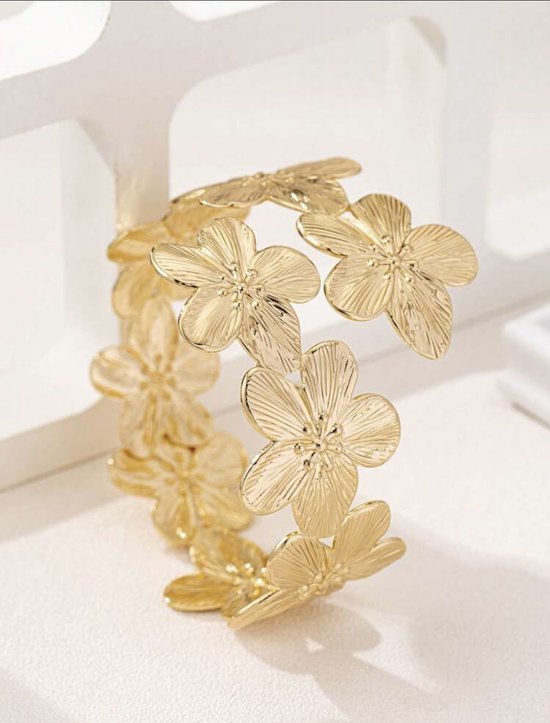 Gouden armband bezet met gestileerde bloemen.