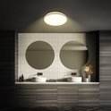 Badkamer met twee ronde spiegels, een badkamermeubel met houten fronten en een rond plafondlicht met houten rand.