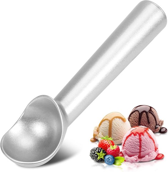 Cuillère à glace argentée devant des boules de glace garnies de fruits et de sauce.