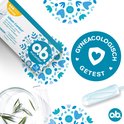 Ob ProComfort Normal tampon, gynecologisch getest. Wit met blauwe bloemen op de achtergrond. Rechtsonder een losse tampon.