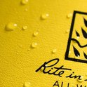 Gele kaft van 'Rite in the Rain' notitieboek met waterdruppels en een deel van een logo met vlammen.