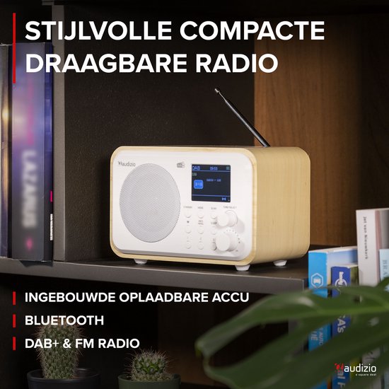 DAB radio met wit front en houten kast, op een boekenplank met andere items.